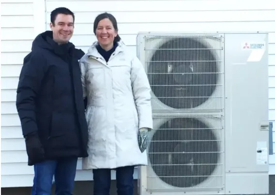 A family standing outside with their heat pumps during winter.