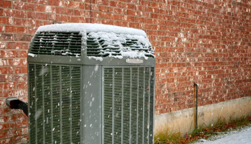 Heat pump installed outside of home in winter