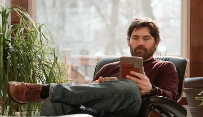 person sitting on chair reading on ipad