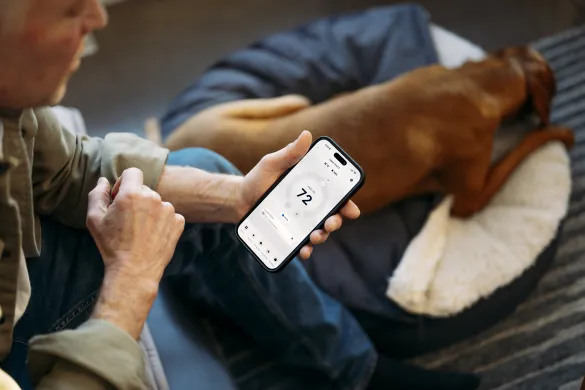 person using phone for thermostat 