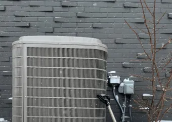 A heat pump on a stand in winter. 