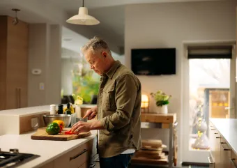 person cutting peppers in their kitchen