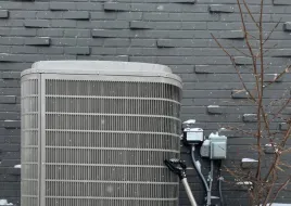 A heat pump on a stand in winter. 